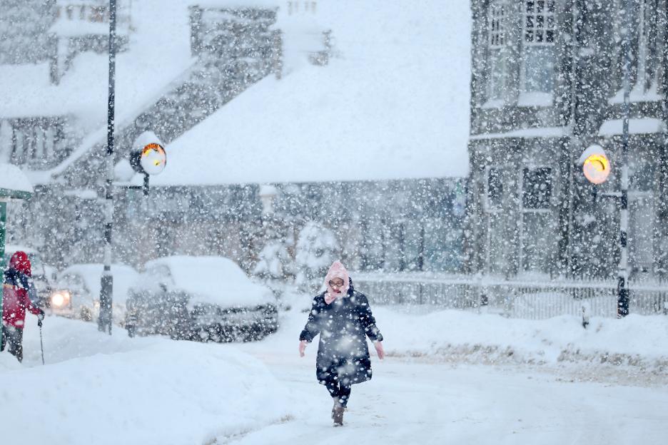 People walking through severe snow in Alford, Scotland.