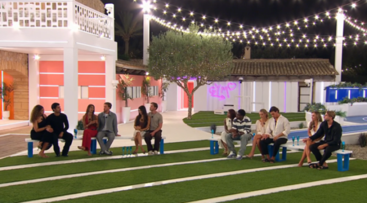 Couples sitting on benches in a brightly lit outdoor area.