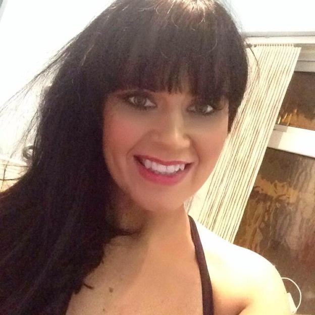 Tammy Hart wearing a black strapless top and long, sparkly earrings.