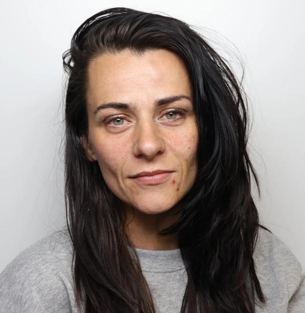A 32-year-old woman with long dark hair, wearing a gray sweatshirt.