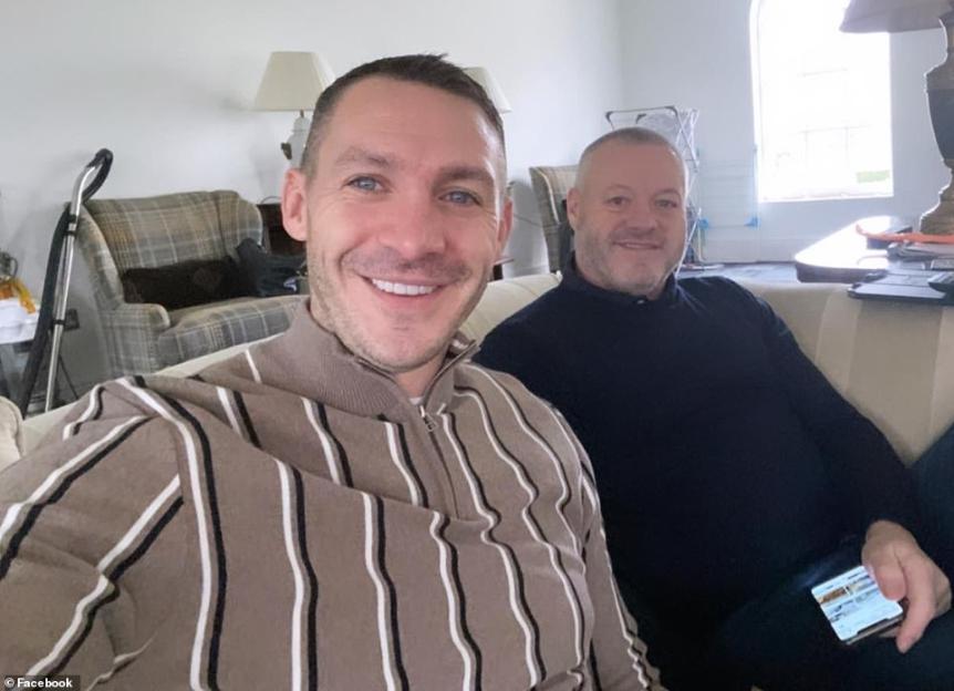 Kirk Norcross and Mick Norcross smiling on a couch.