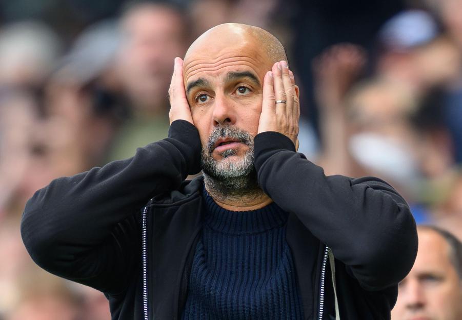 Manchester City manager Pep Guardiola with his hands on his head looking up.