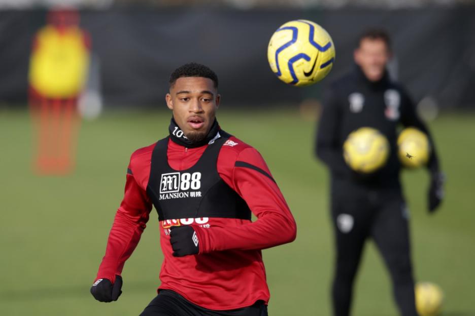 AFC Bournemouth player in a red shirt and black training bib during a training session.