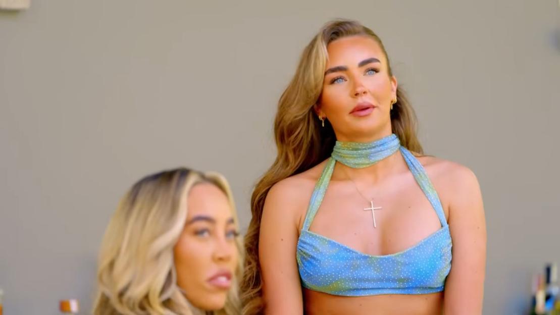 A woman in a blue halter-neck top and choker.