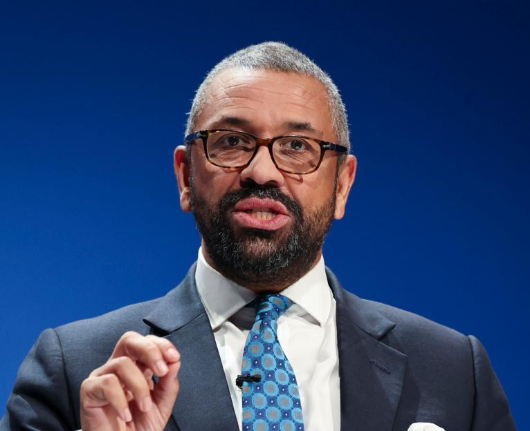 Sir James Cleverly speaking on stage at the Conservative Party Conference.