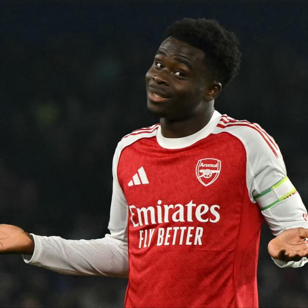 Arsenal midfielder Bukayo Saka shrugging his shoulders after scoring a goal.