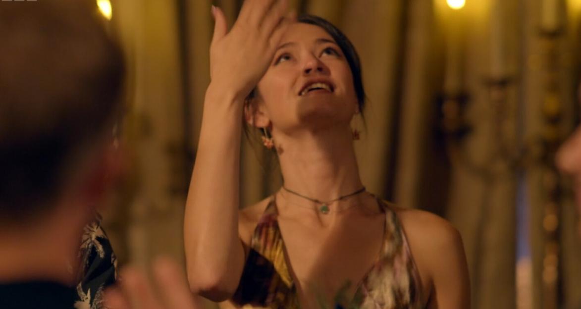 Jade, looking up with her hand on her forehead, during a game of The Traitors.