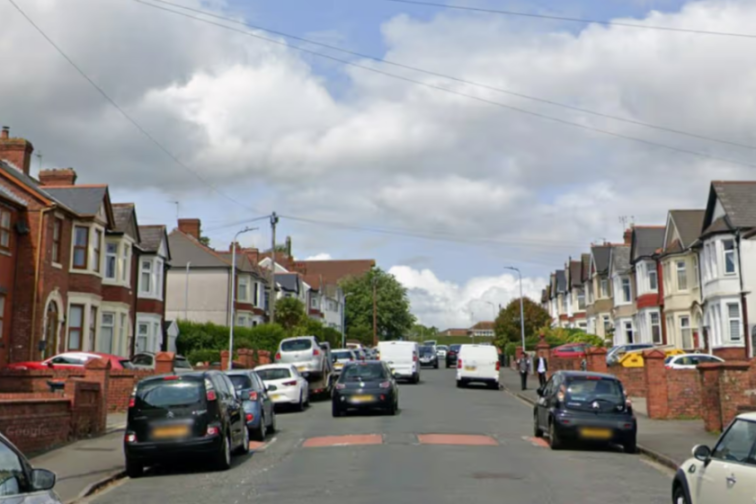 Street view of St Julian's Avenue in Cardiff, lined with houses and parked cars.
