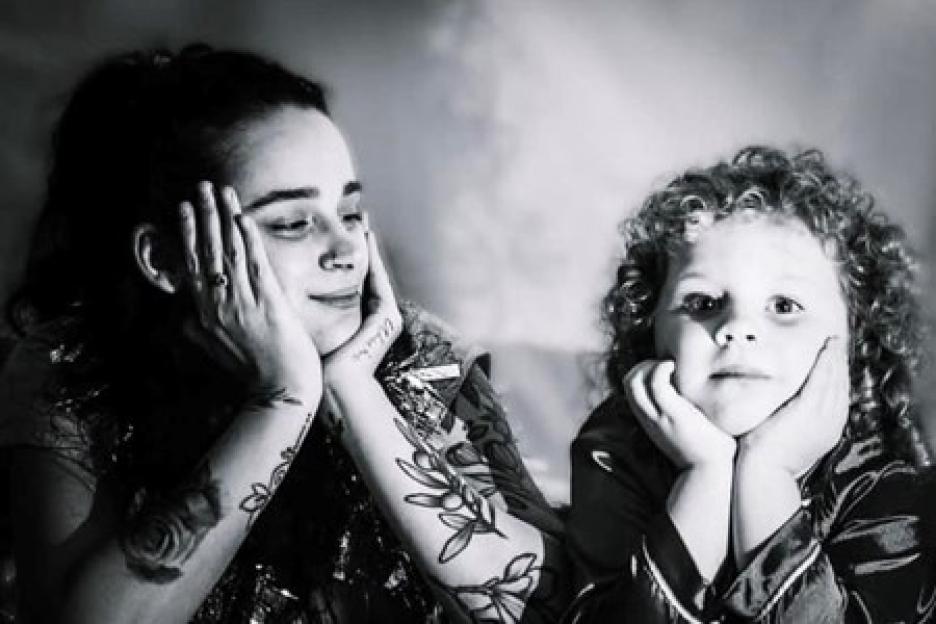 Black and white photo of Destiny Harrison and her daughter Linnea, both resting their chins on their hands.