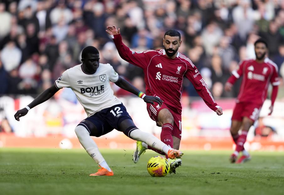 Mohamed Salah and El Hadji Malick Diouf battle for the ball during a Premier League match.