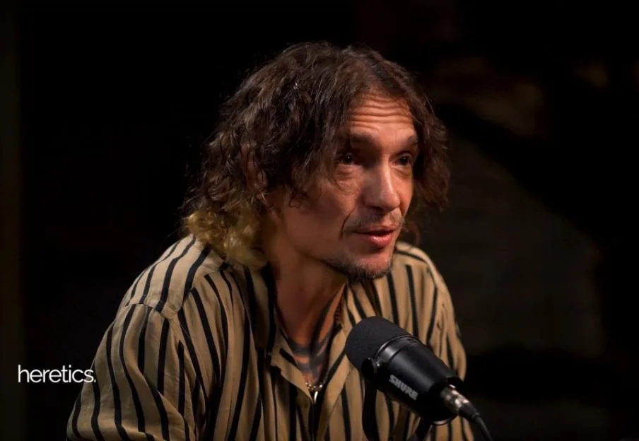 Justin Hawkins of The Darkness speaks into a Shure microphone.