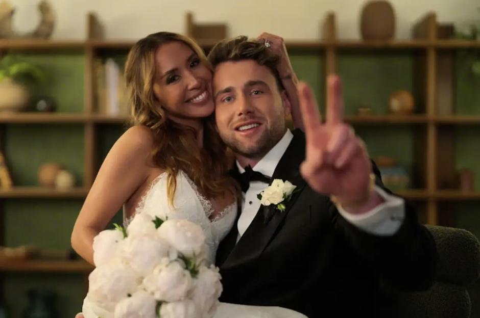Harry Jowsey and Amber Mozo of "Let's Marry Harry" pose together, Jowsey making a peace sign with his left hand.