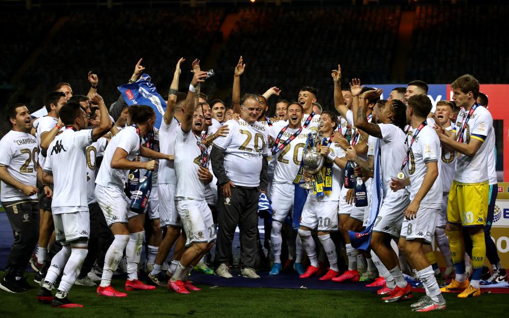 Leeds United players and manager Marcelo Bielsa celebrating with the Sky Bet Championship trophy.