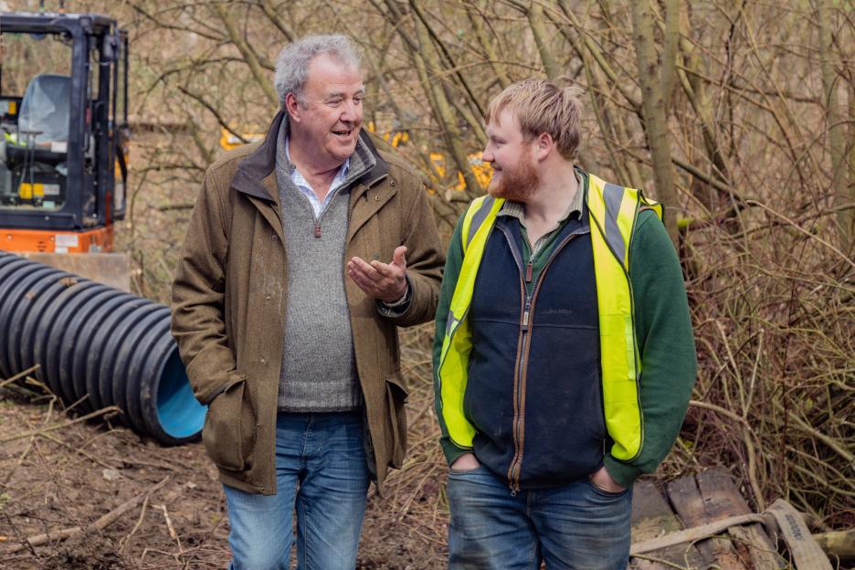 two men standing next to each other with one wearing a yellow vest that says ' abercrombie & fitch ' on it