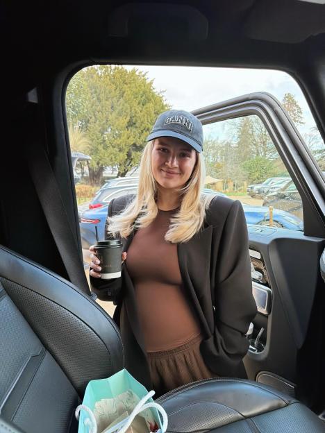 Molly-Mae Hague exiting a car, holding a cup.