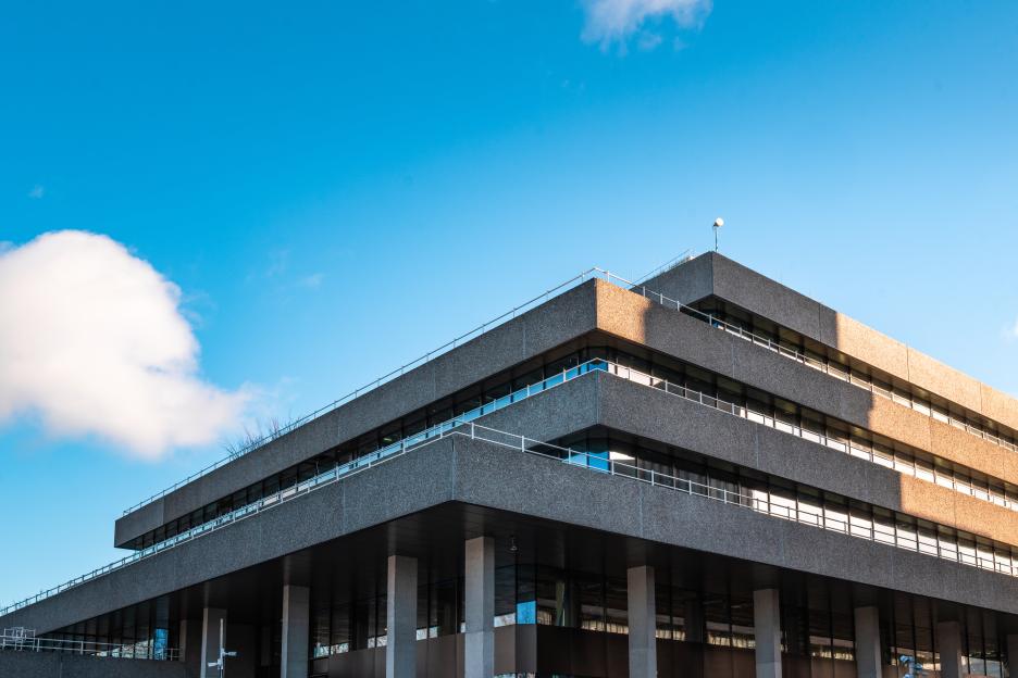 National Theatre in London, with a section of the brutalist concrete facade brightly lit by sunlight.