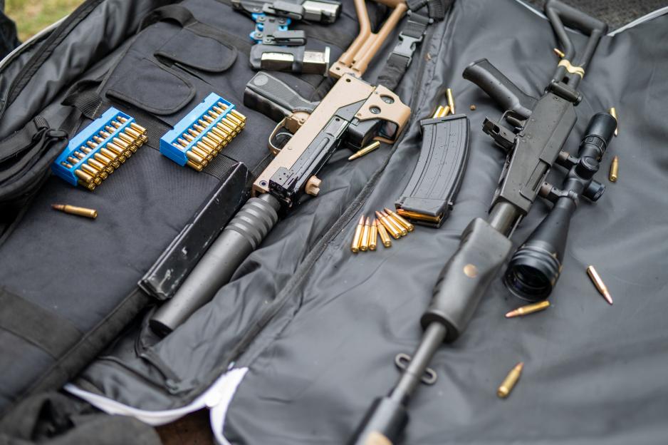 High-angle view of two rifles and ammunition on a black gun case.