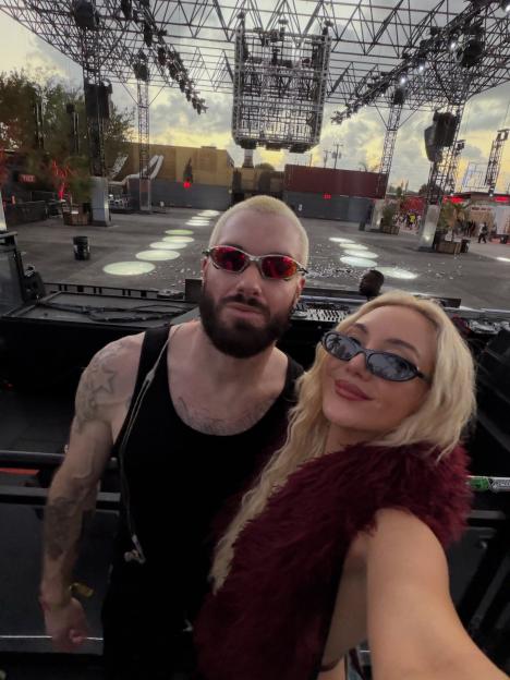 James Hype and a woman pose for a selfie at an outdoor music event.