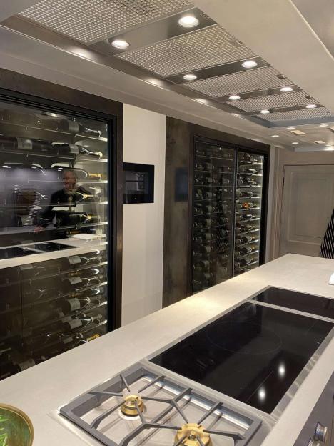 Two wine coolers containing multiple bottles of wine in a modern kitchen.