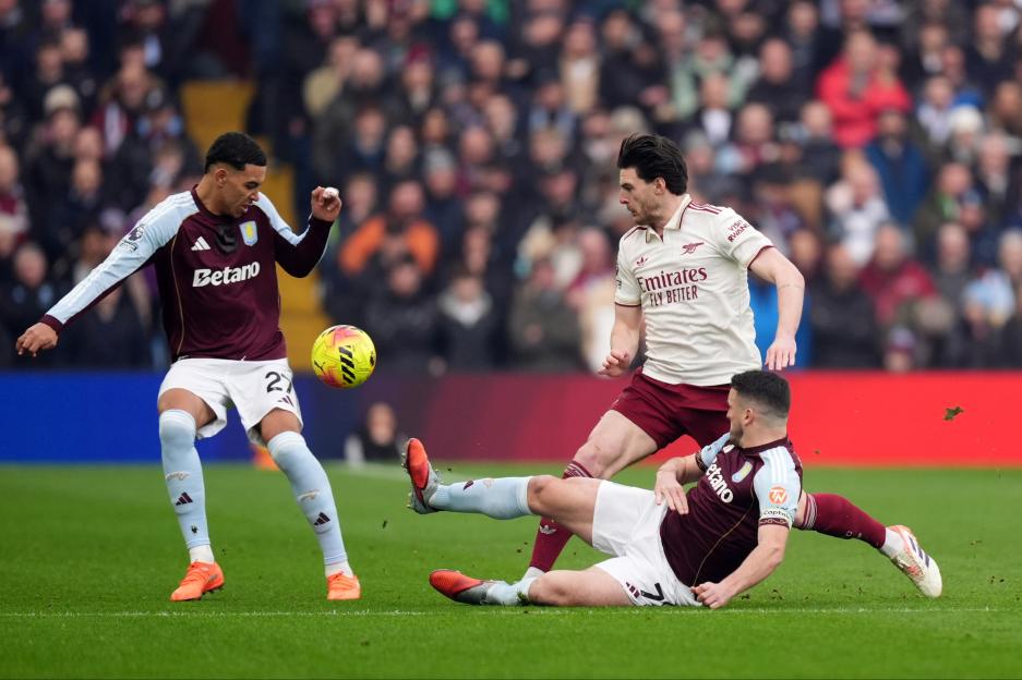 Arsenal's Declan Rice battles for the ball with Aston Villa's Morgan Rogers and John McGinn.
