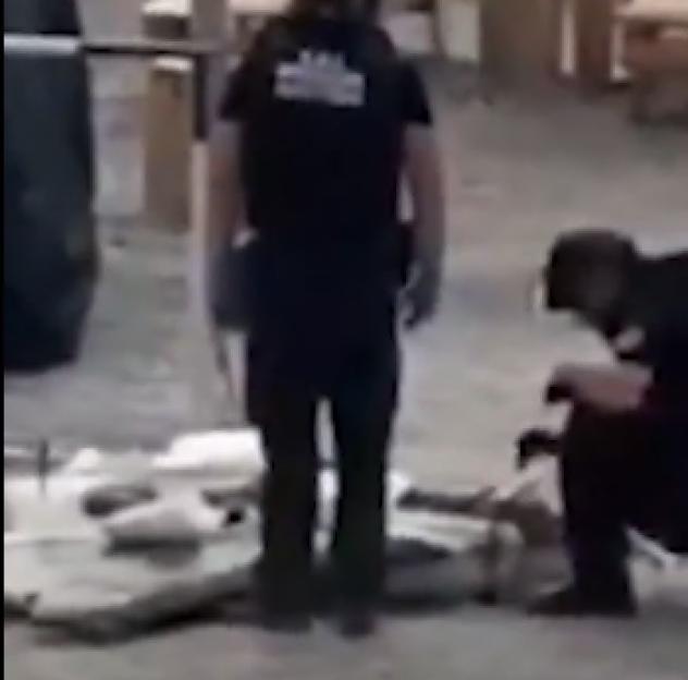 Bomb squad personnel examining an explosive-laden drone.