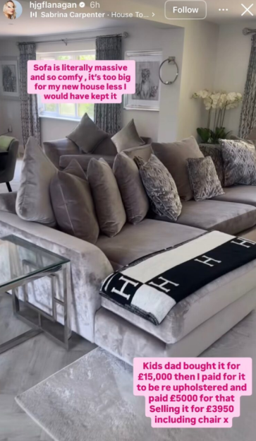 A large gray sofa with many pillows and a black and white blanket with "H" logos.