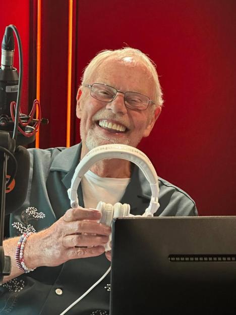 Bob Harris holding headphones and smiling broadly.