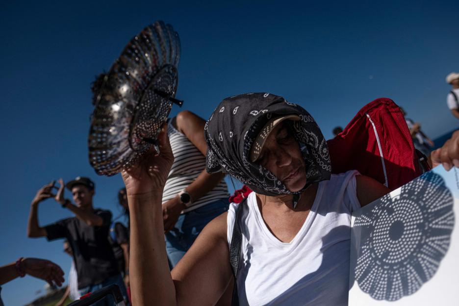 A woman watching an annular eclipse through a pinhole projector.