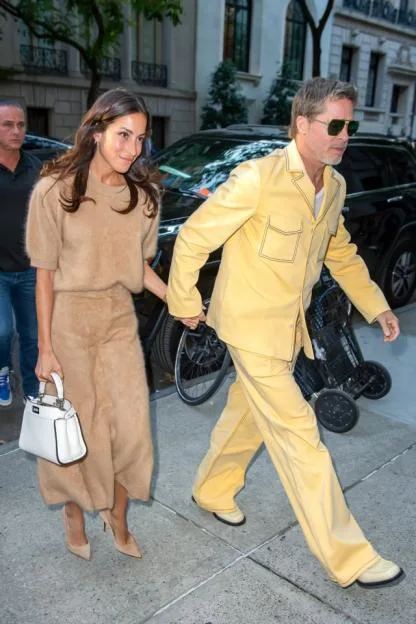 Ines de Ramon and Brad Pitt walking together on a city street.