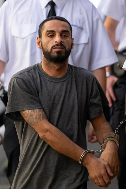 Asylum seeker Mohammed Abbas in handcuffs being led into Cardiff Crown Court.