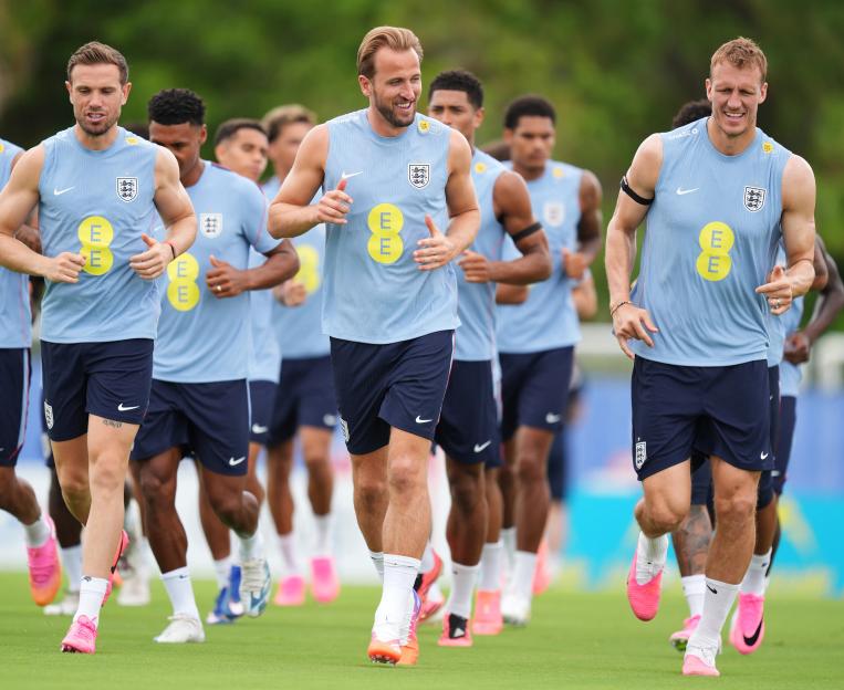England's Harry Kane, Jordan Henderson, and Dan Burn jogging during a national soccer team training session.
