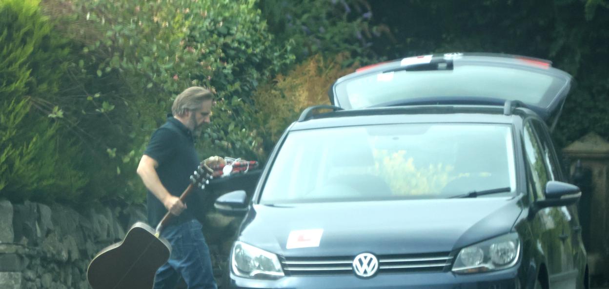Rev Edward Lyons loading his belongings, including a guitar, into a car.