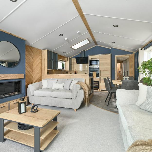 Living room, dining, and kitchen area inside a holiday park lodge.