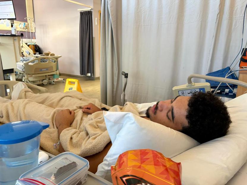 Kahlan Eales lying in a hospital bed, after using ChatGPT to diagnose himself.