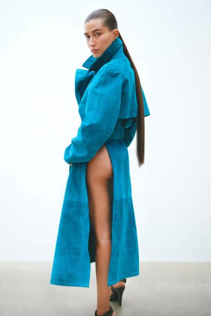 Hailey Bieber in a turquoise suede goatskin overcoat and satin mules.