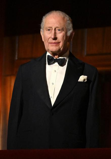 King Charles III in a black tuxedo and bow tie.