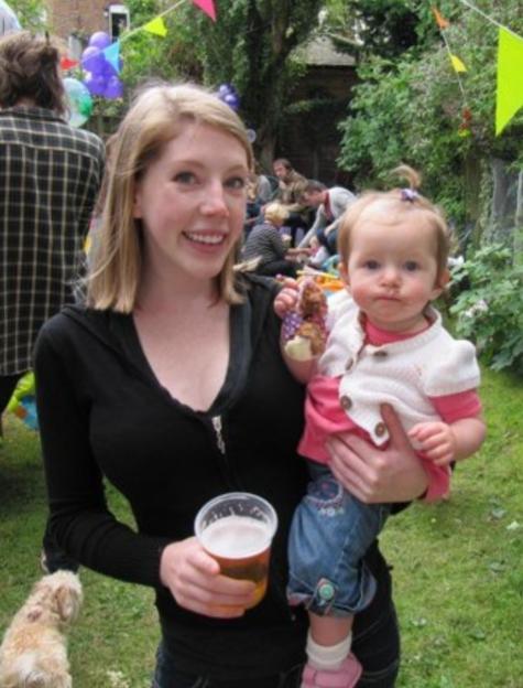 Katherine Ryan holding her daughter in a garden.