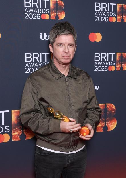Noel Gallagher holding two awards at The BRIT Awards 2026.