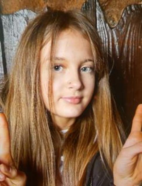 A missing girl, Emily, with long brown hair, looking directly at the camera.