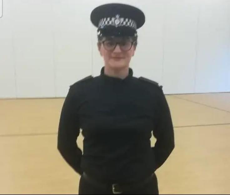 A woman with glasses and two boys, all with pixelated faces, standing on a porch with trailer homes in the background.