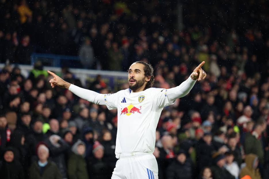 Dominic Calvert-Lewin celebrates scoring a goal for Leeds, pointing to the sky with both hands.
