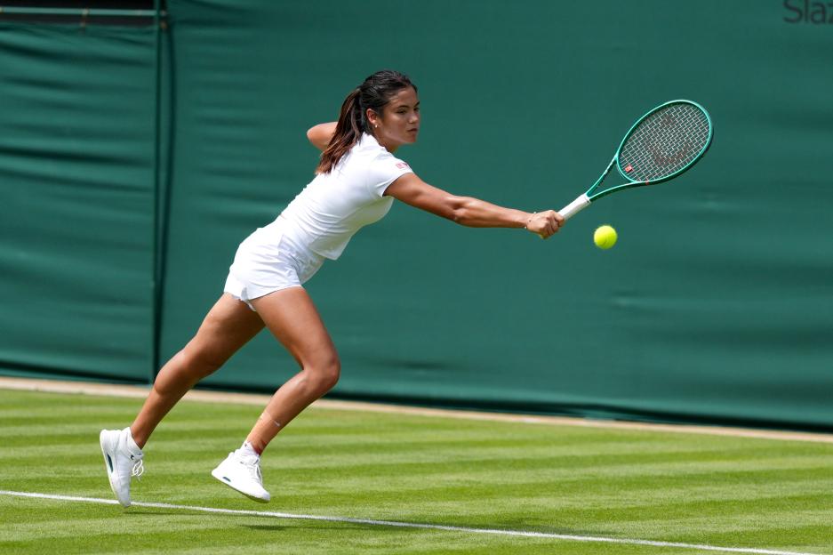 Emma Raducanu hitting a forehand shot on a tennis court.