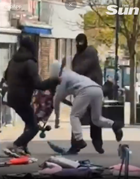 Three people engaged in a machete fight on a street.