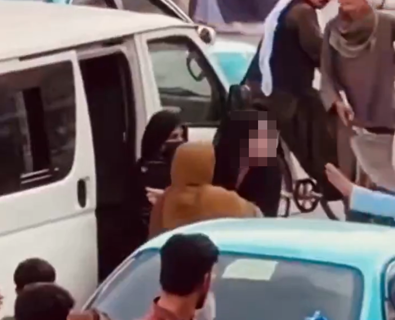 Women being rounded up by Taliban female guards.