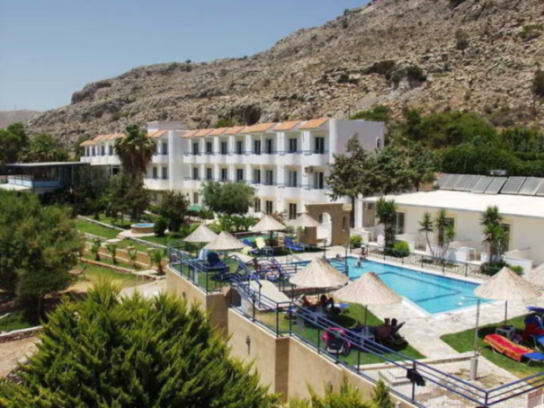 Ilyssion Hotel with a pool and mountain in the background.