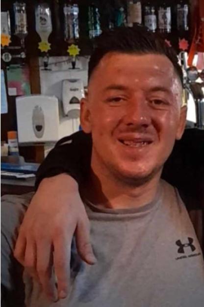 A man identified as Ricky Harris smiling at the camera, with a bar in the background.