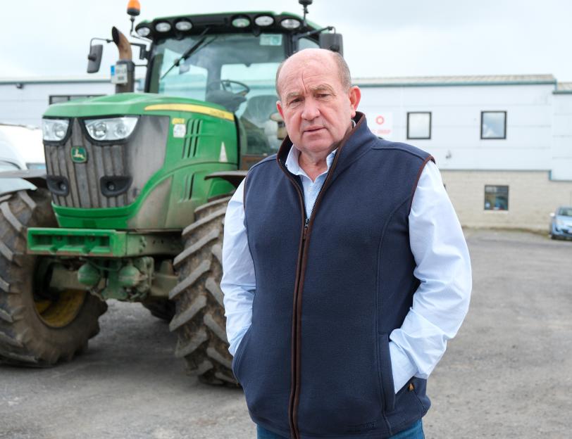 Beef farmer and agricultural contractor John Dallon in front of a green tractor.