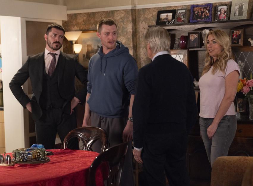 Adam Barlow, Daniel Osbourne, Ken Barlow, and another person standing in a room, with Daniel appearing to be upset.