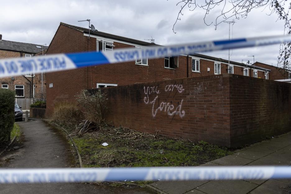 Police tape strung across the scene of a house fire in Rusholme, South Manchester.