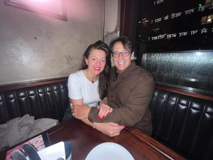 A man and woman sitting together in a cozy booth.